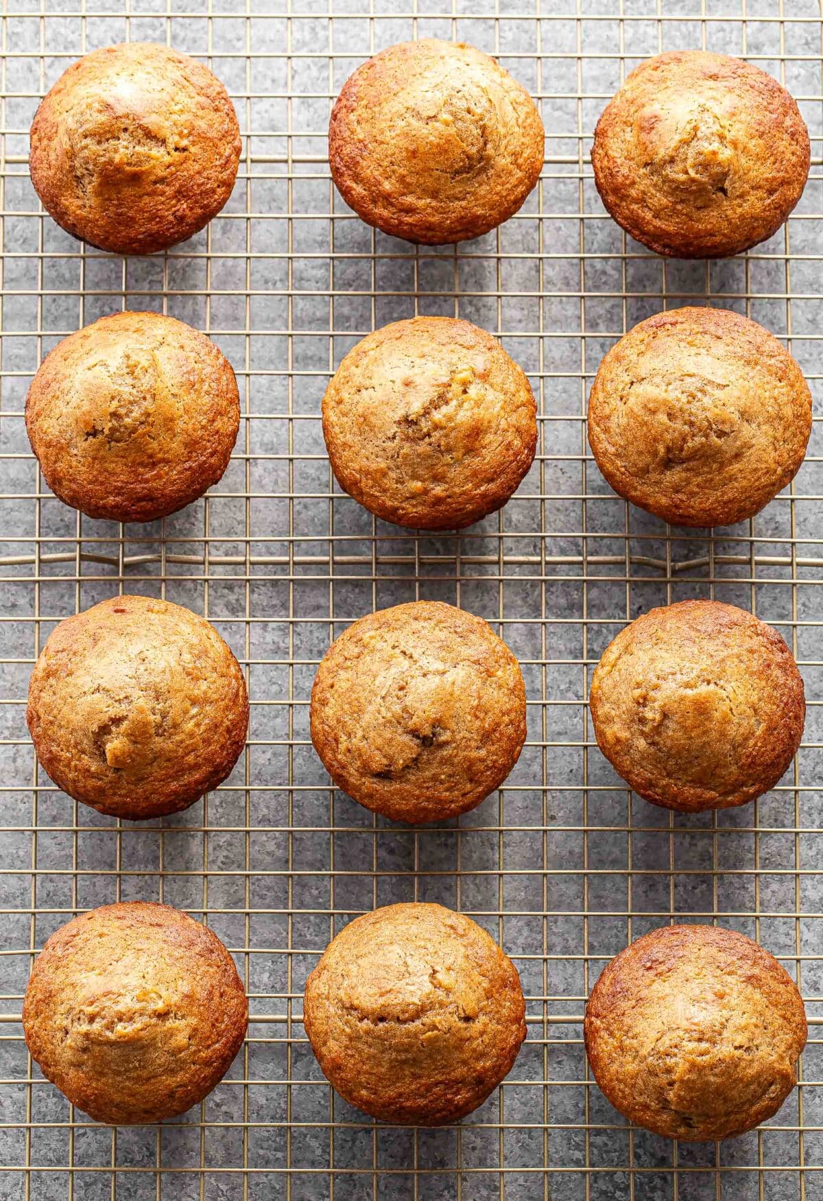 12 banana muffins on a wire cooling rack.
