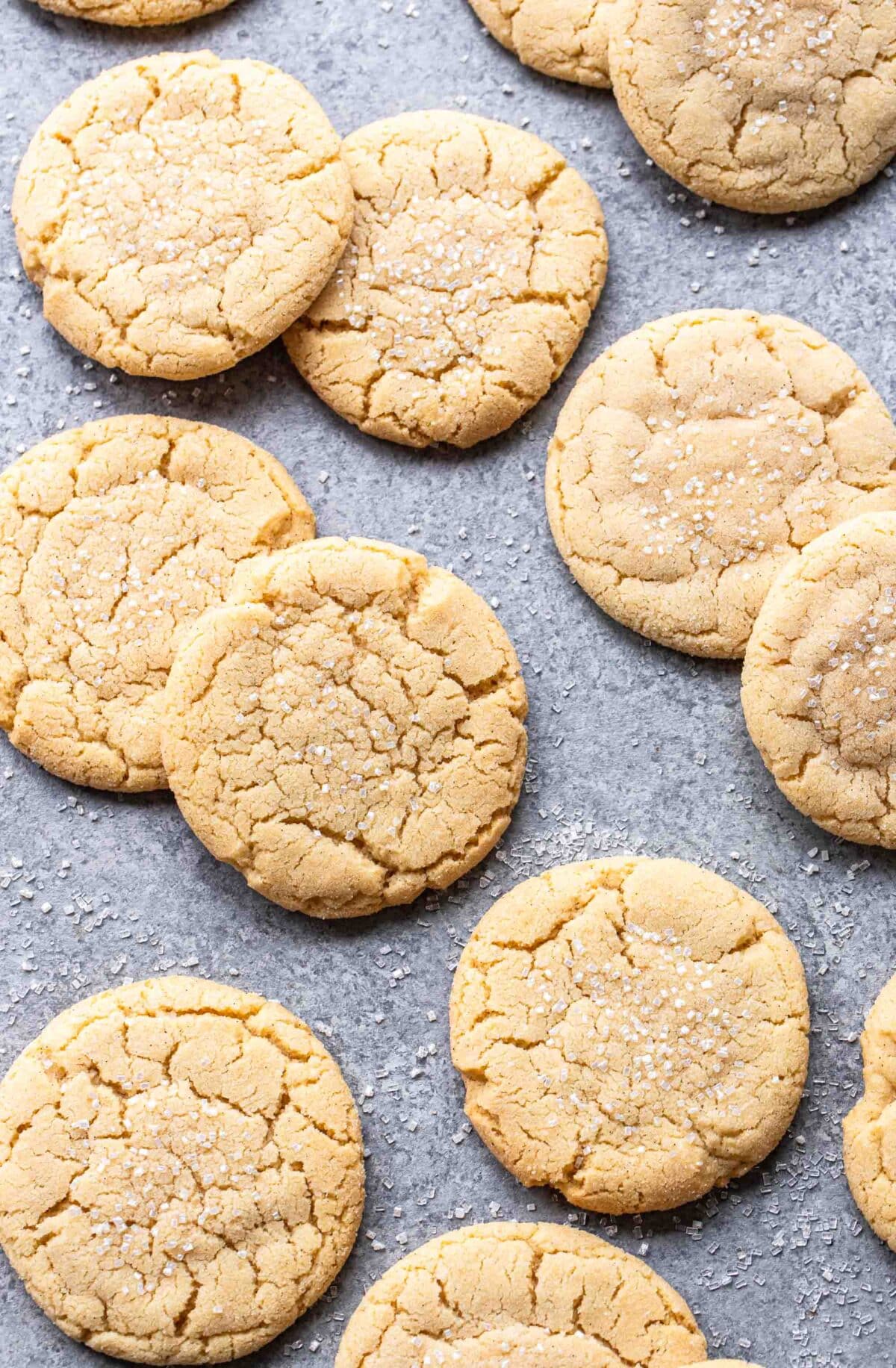 A bunch of sugar cookies on a gray surface.