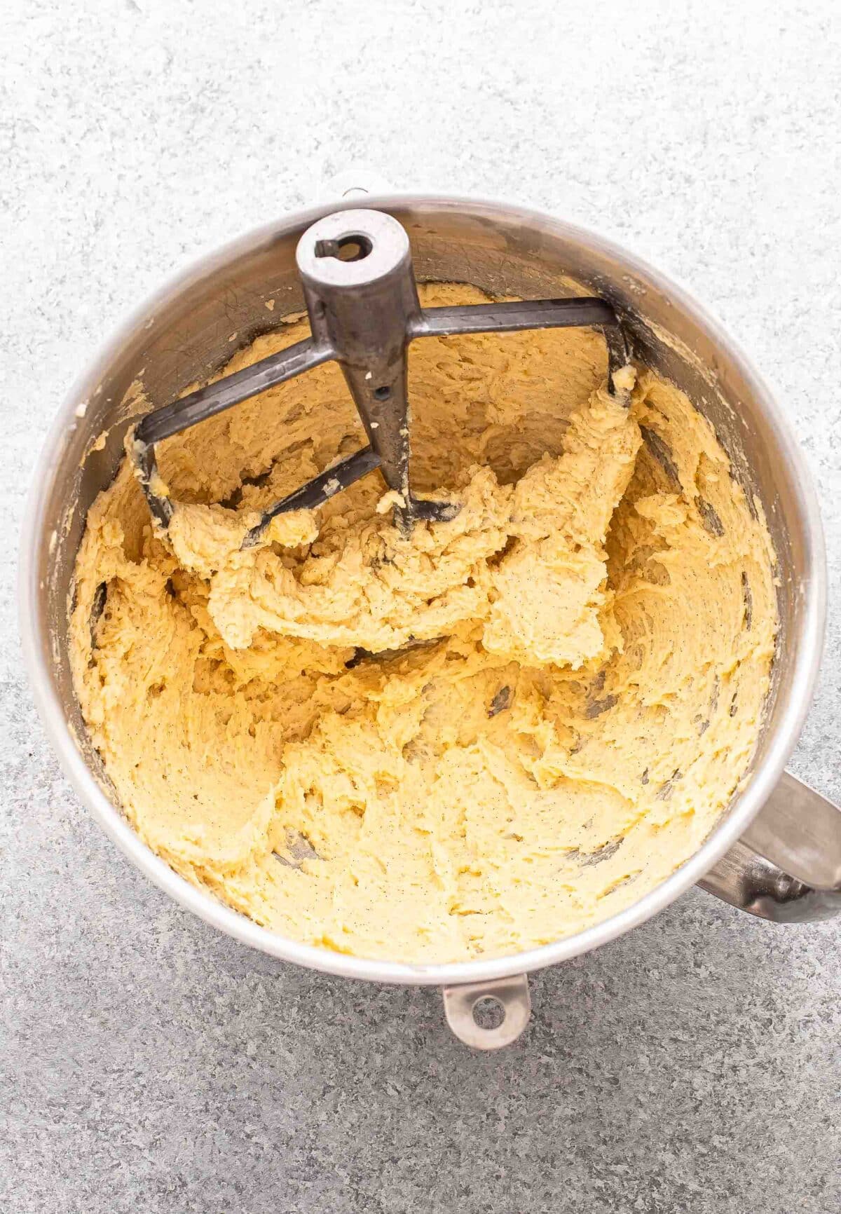 Sugar cookie dough before the flour is added in in a mixing bowl.