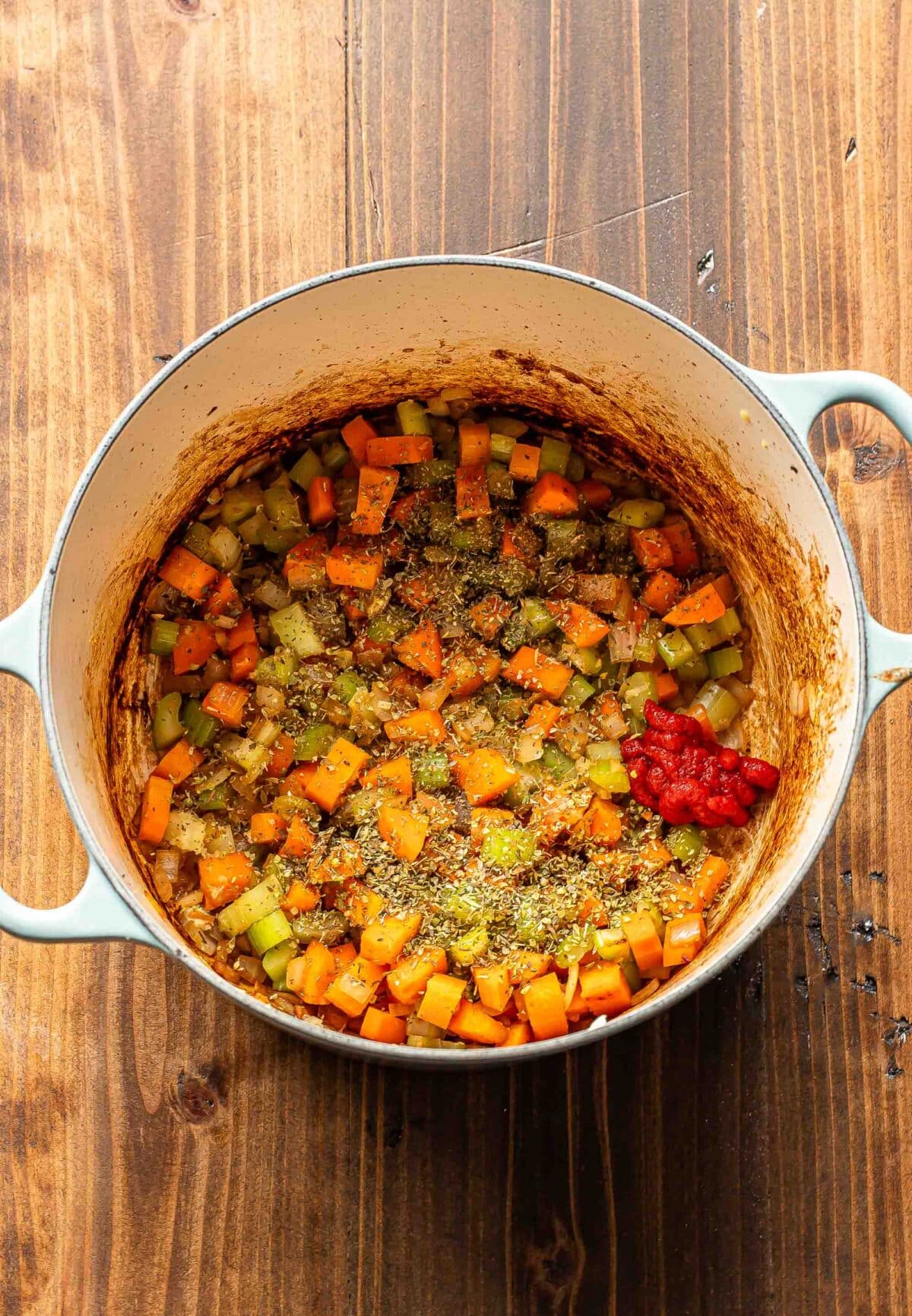 Cooked vegetables and tomato paste in a pot.