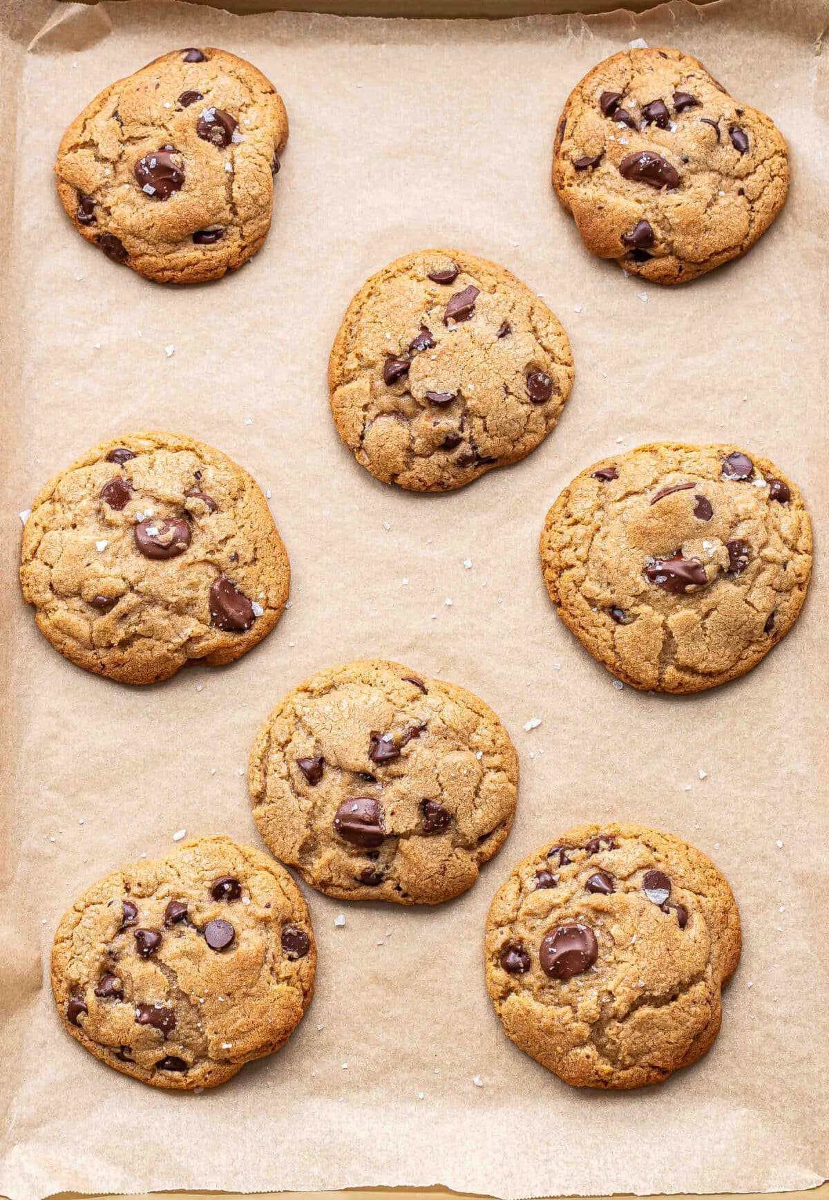 Chocolate chip cookies on a parchment paper lined baking pan.