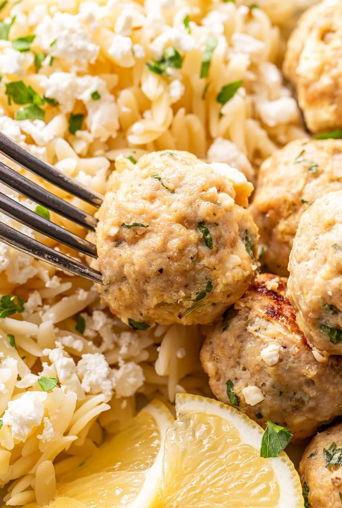 A fork picking up a Greek chicken meatball.