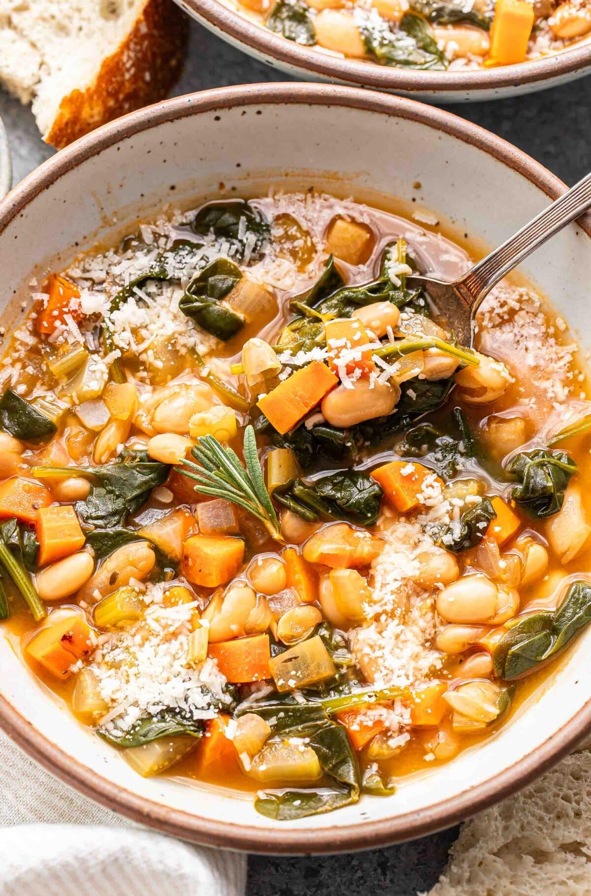 White bowl with white bean soup in it and a bowl.