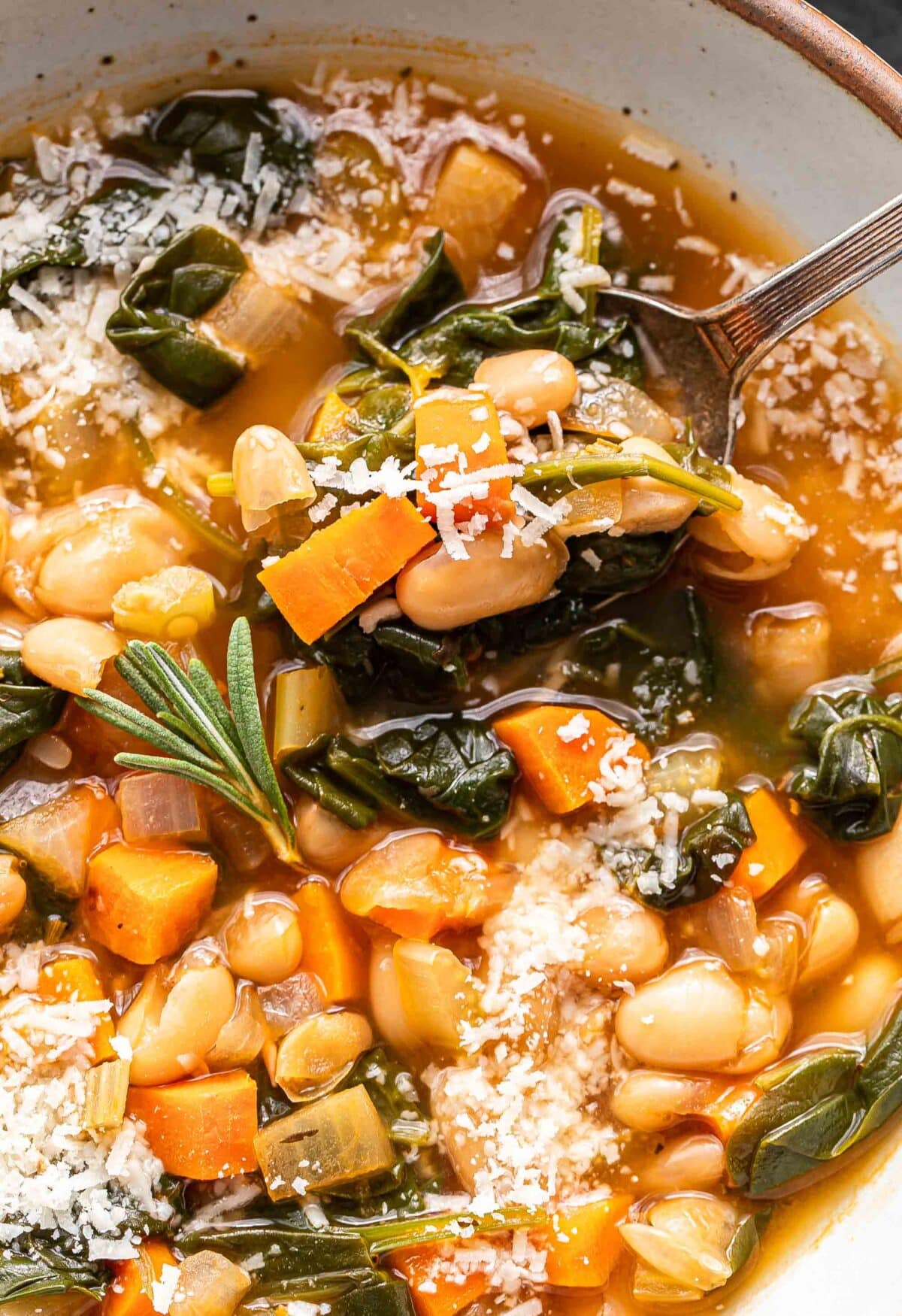 White bean soup in a white bowl with a spoon.