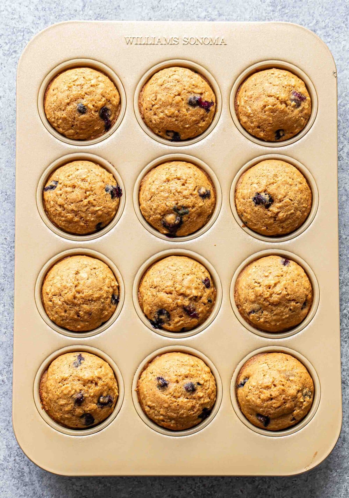 12 blueberry oatmeal muffins in a muffin pan.