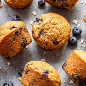 Blueberry oatmeal muffins scattered on a gray surface.