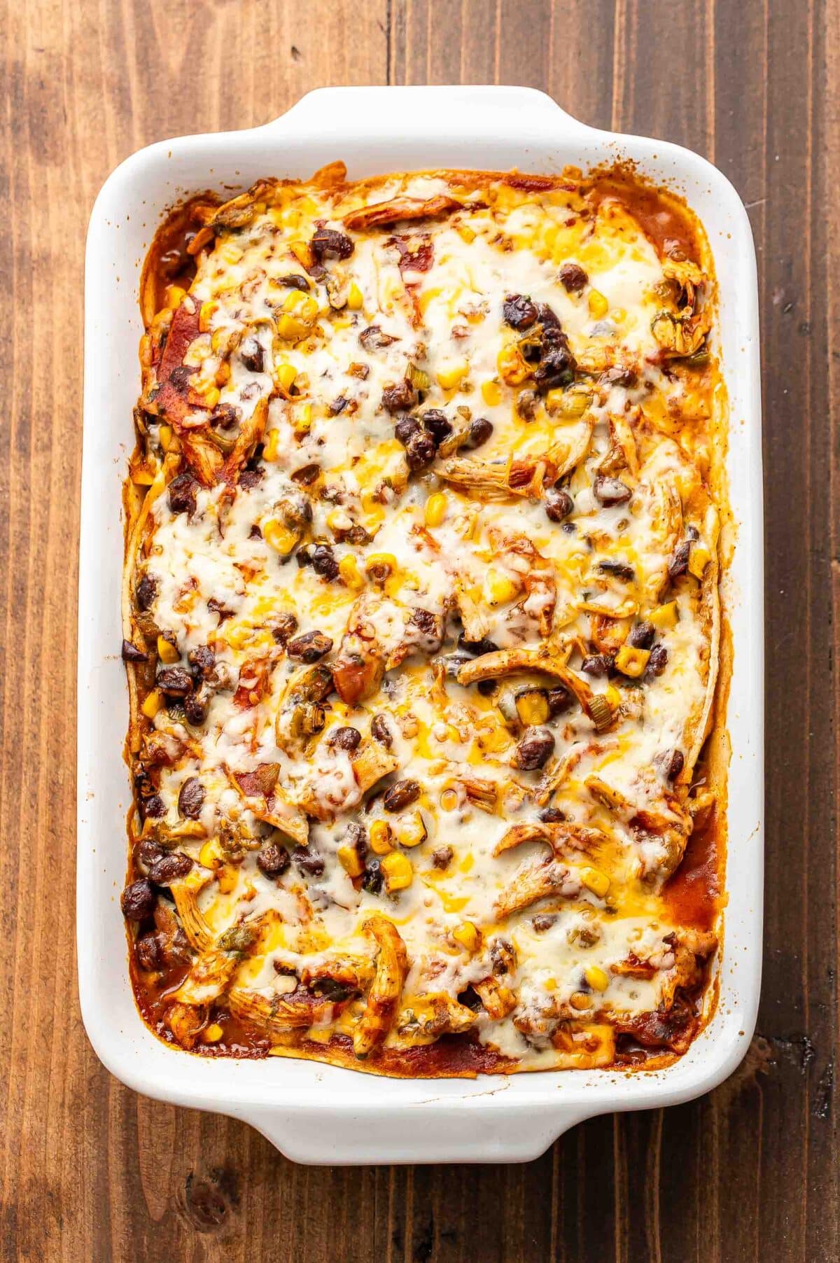 Chicken enchilada casserole in a rectangular white dish.