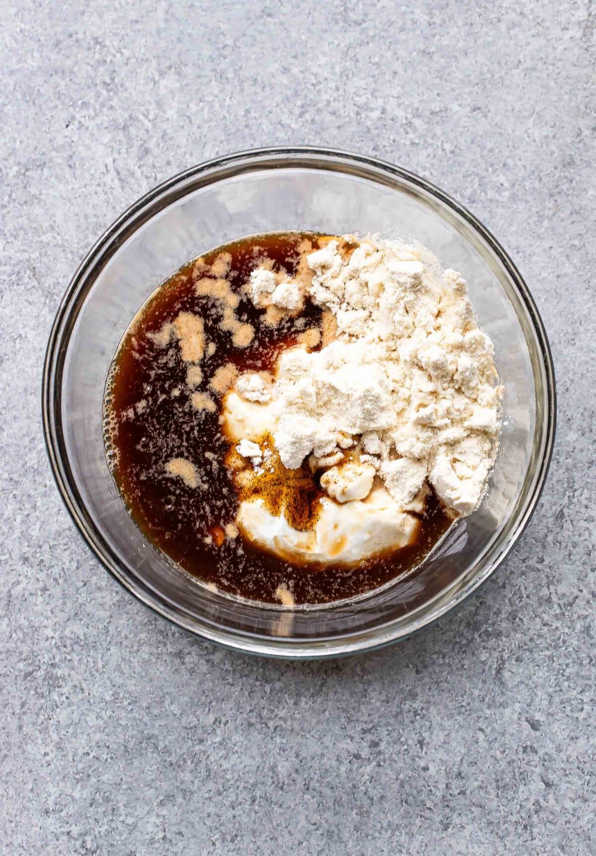 Ingredients for coffee overnight oats in a glass mixing bowl before they've been stirred together.