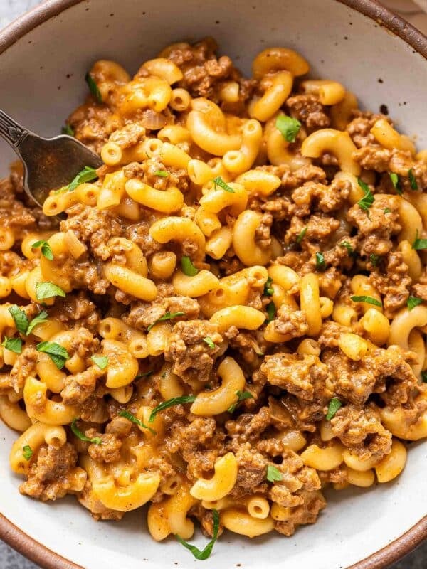 Hamburger helper in a white bowl with a fork.