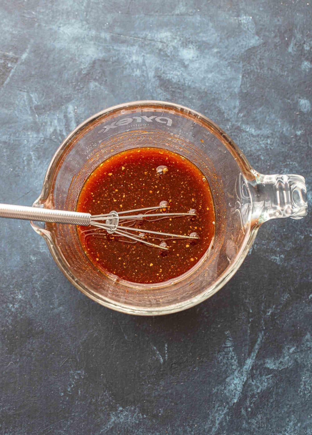 Maple soy glaze for salmon in a glass measuring cup.