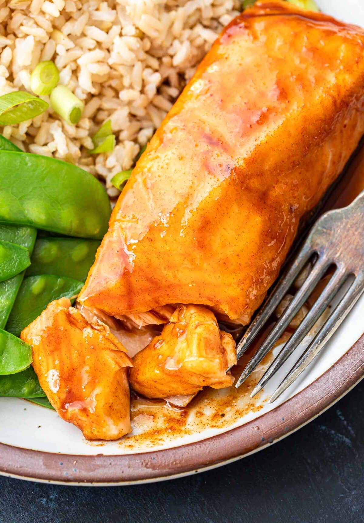 A piece of maple salmon on a plate with the end broken off.
