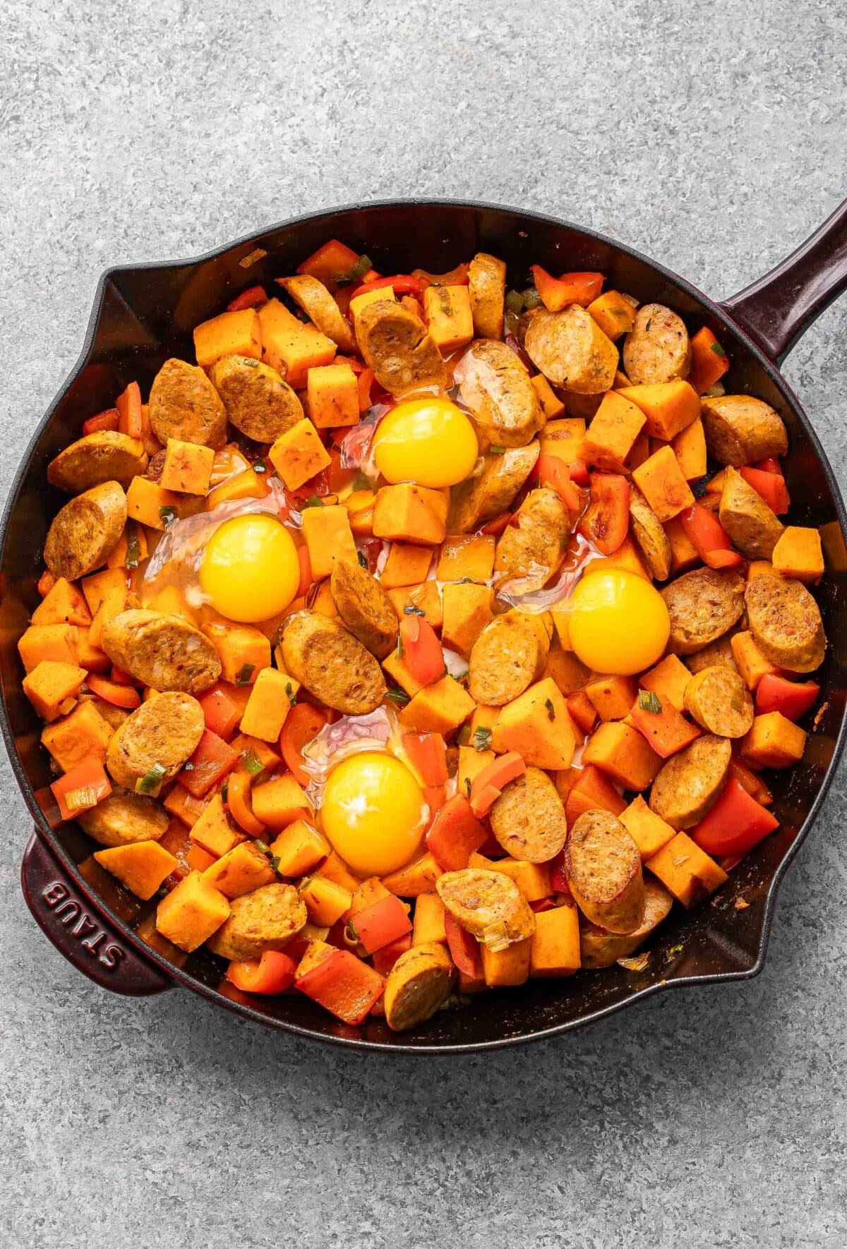 Sweet potato with 4 eggs on top before it's been baked.