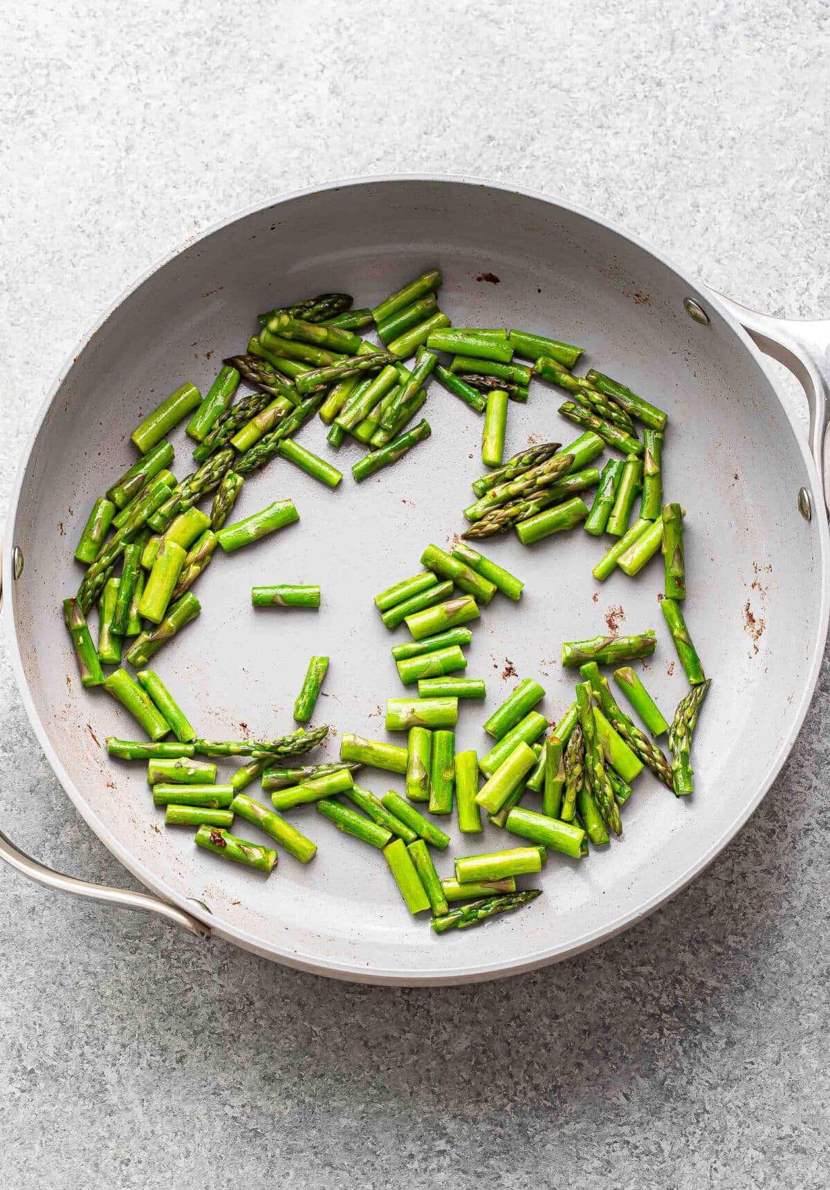 Chopped asparagus in a skillet.