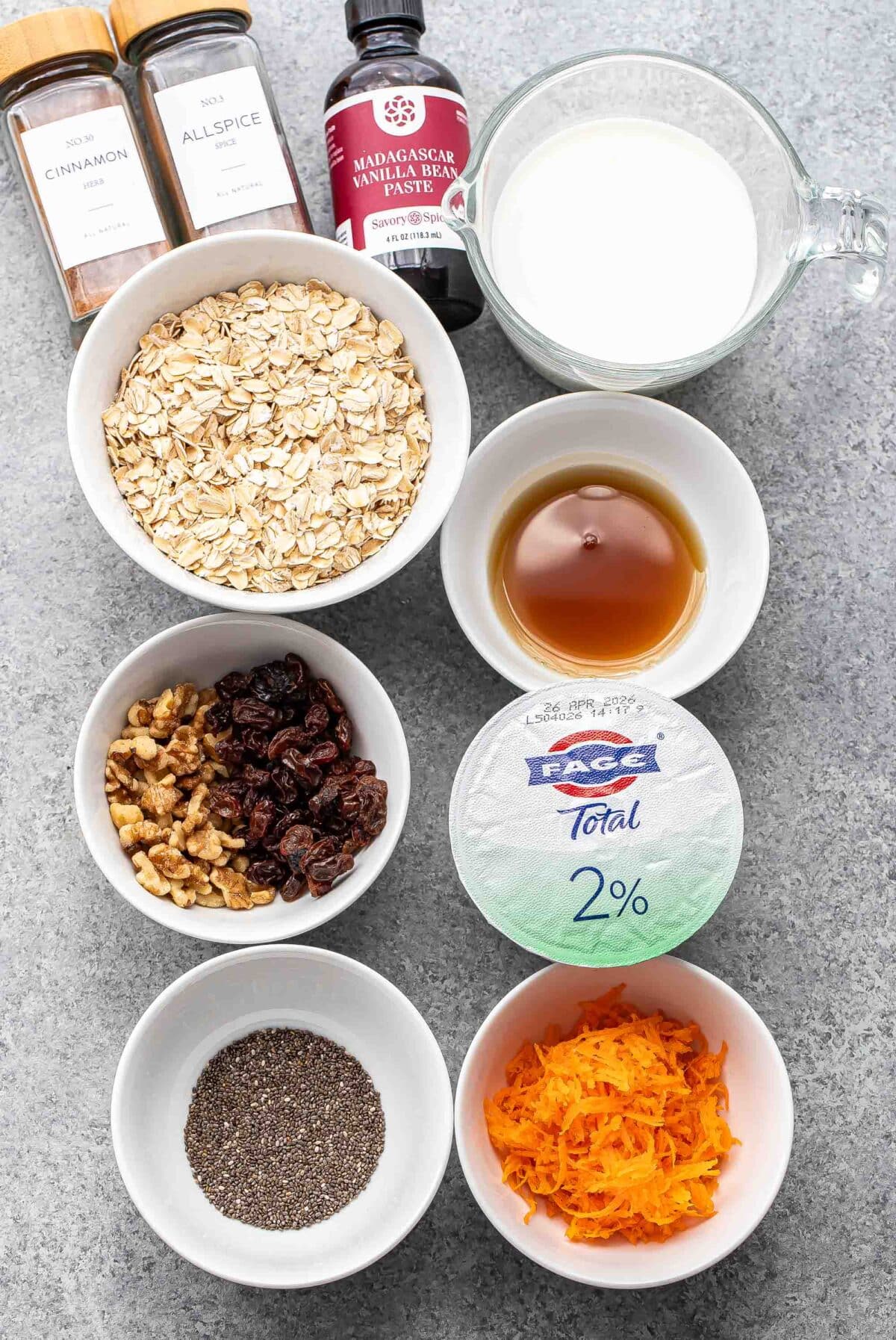 Ingredients used to make carrot cake overnight oats in white bowls.