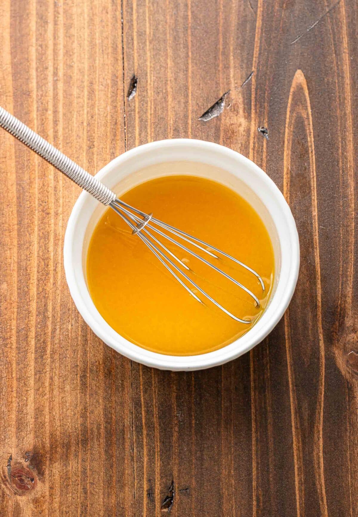 Honey butter in a white bowl with a whisk.
