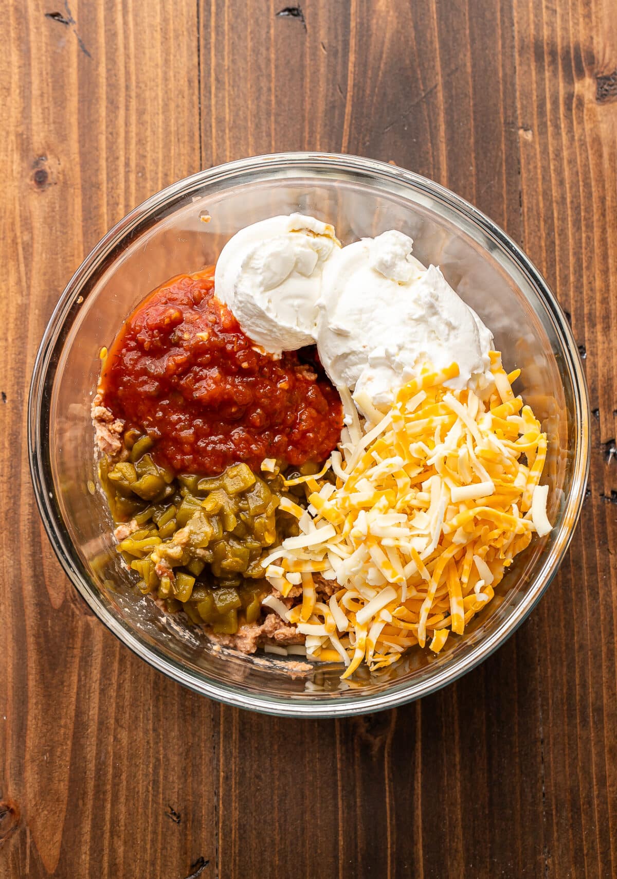 Bean dip ingredients in a glass bowl before they've been mixed together.