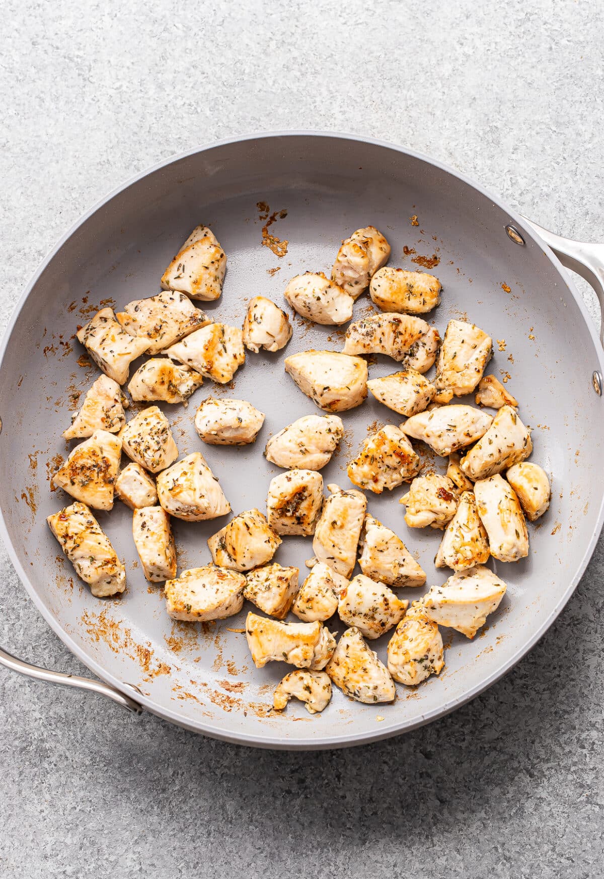 Chunks of cooked chicken in a pan.