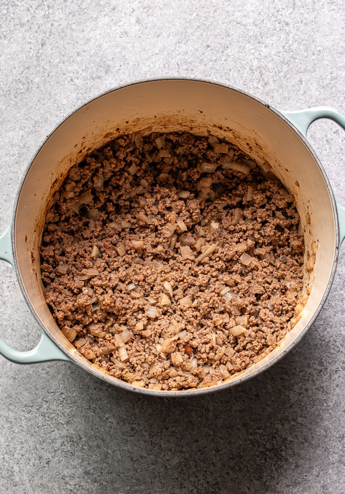 Ground beef and onions in a pot.