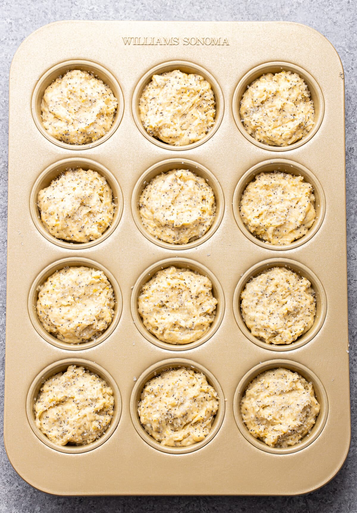 lemon poppy seed muffin batter in a muffin pan.
