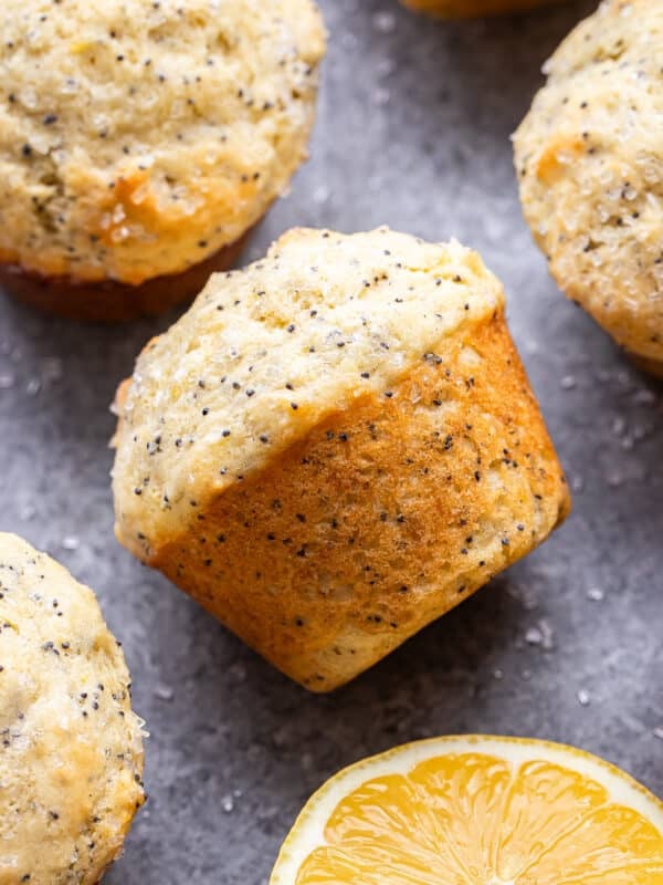 Lemon poppy seed muffin on it's side with half a lemon next to it.
