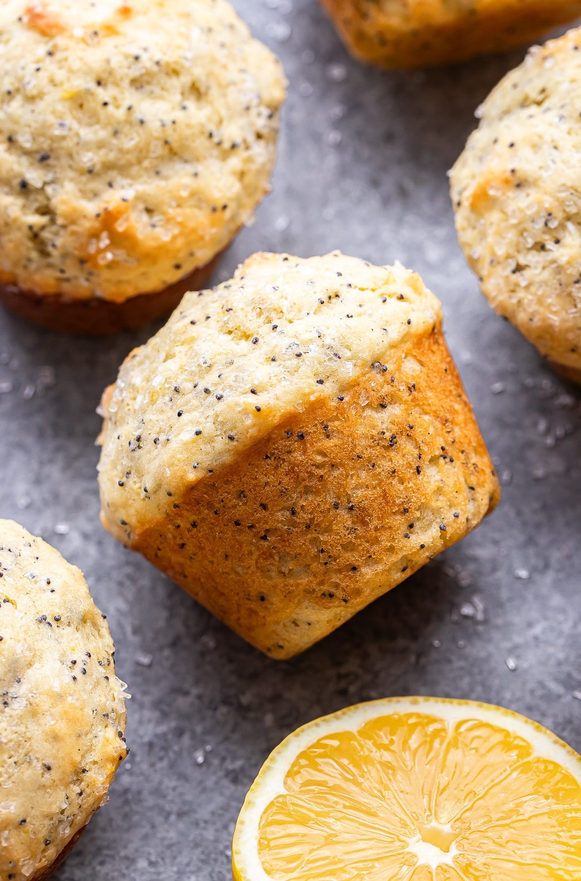 Lemon poppy seed muffin on it's side with half a lemon next to it.