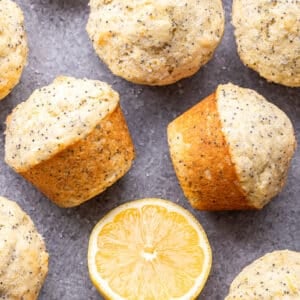 Lemon poppy seed muffins with half of a lemon next to them.