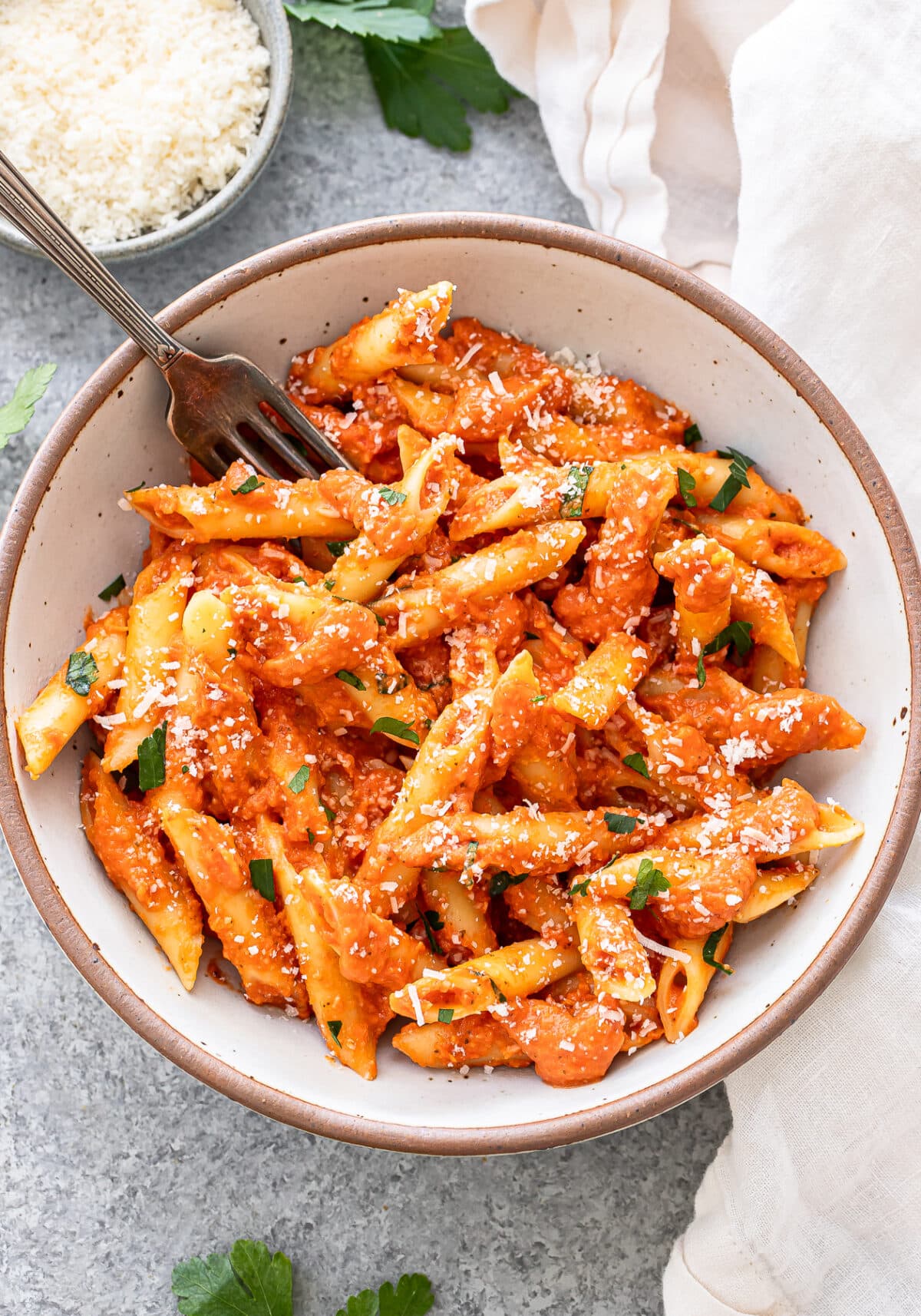 Penne alla vodka in a white bowl with a fork.