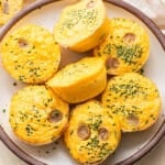 Seven egg bites on a white plate.