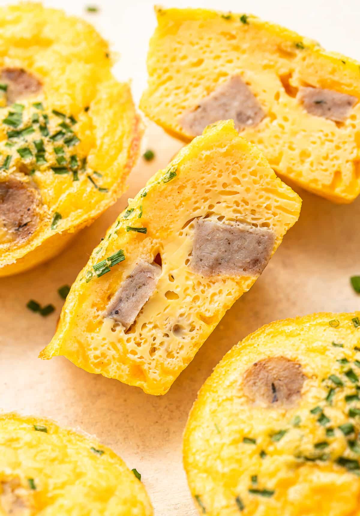 Three egg bites with one cut in half so you can see the inside.