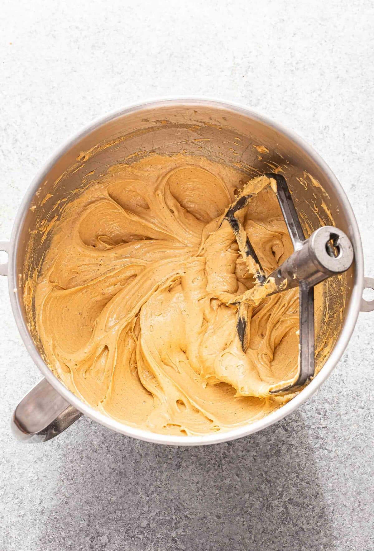 Peanut butter cookie dough in a mixer bowl before the flour is added in.