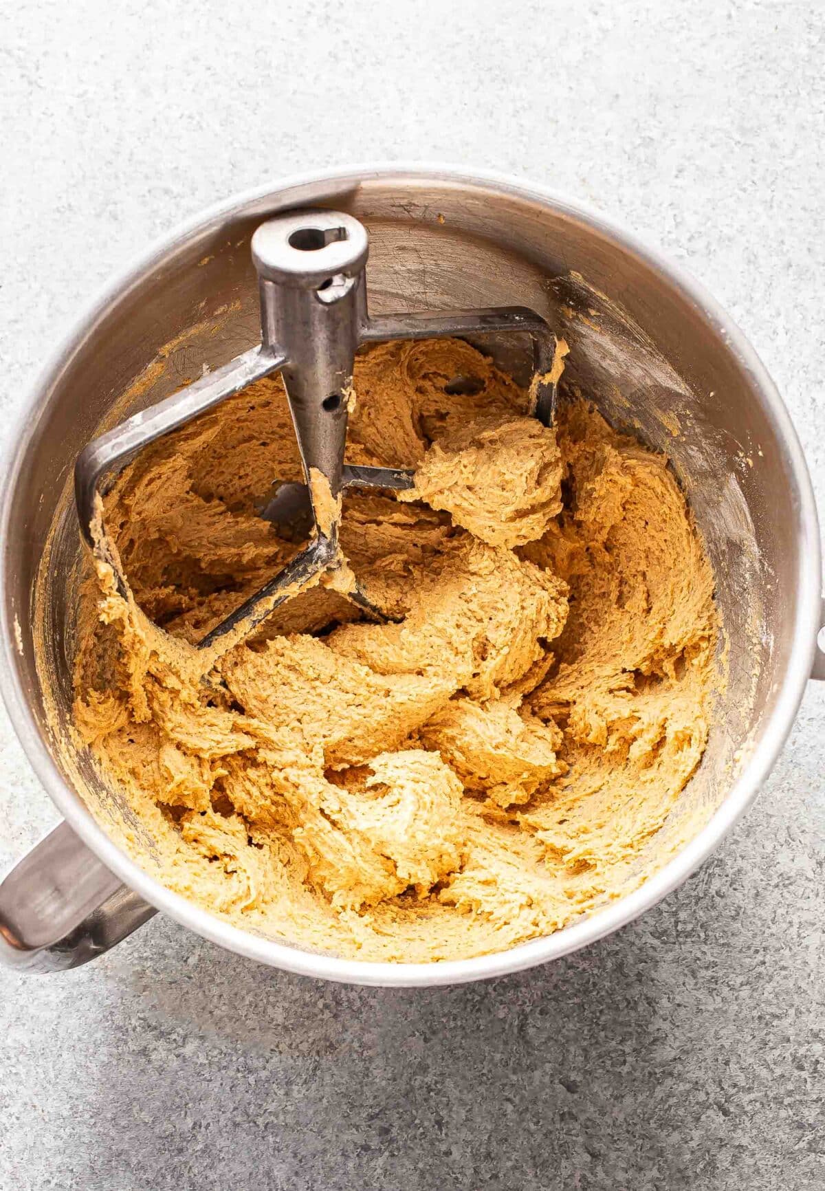 Peanut butter cookie dough in a mixer bowl with the paddle attachment.