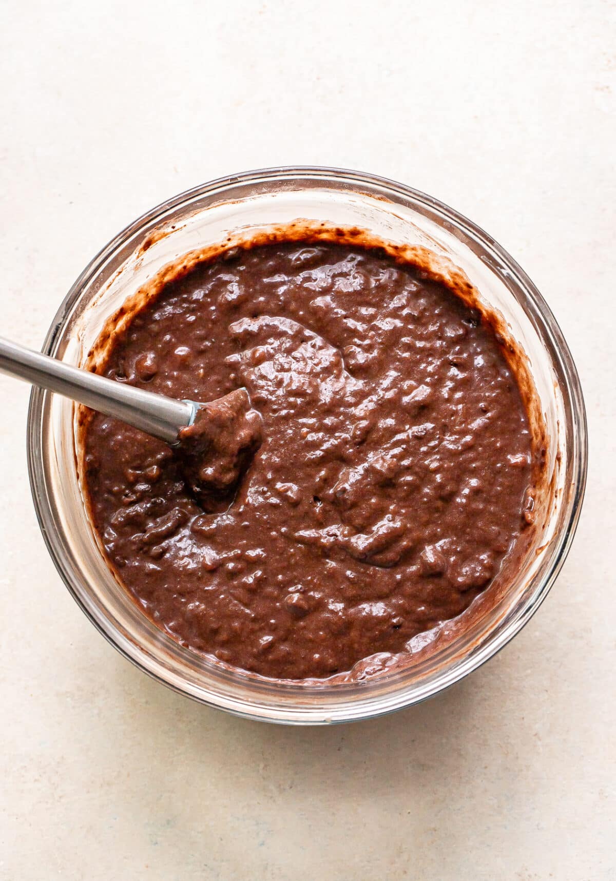 Chocolate banana bread batter in a glass mixing bowl.