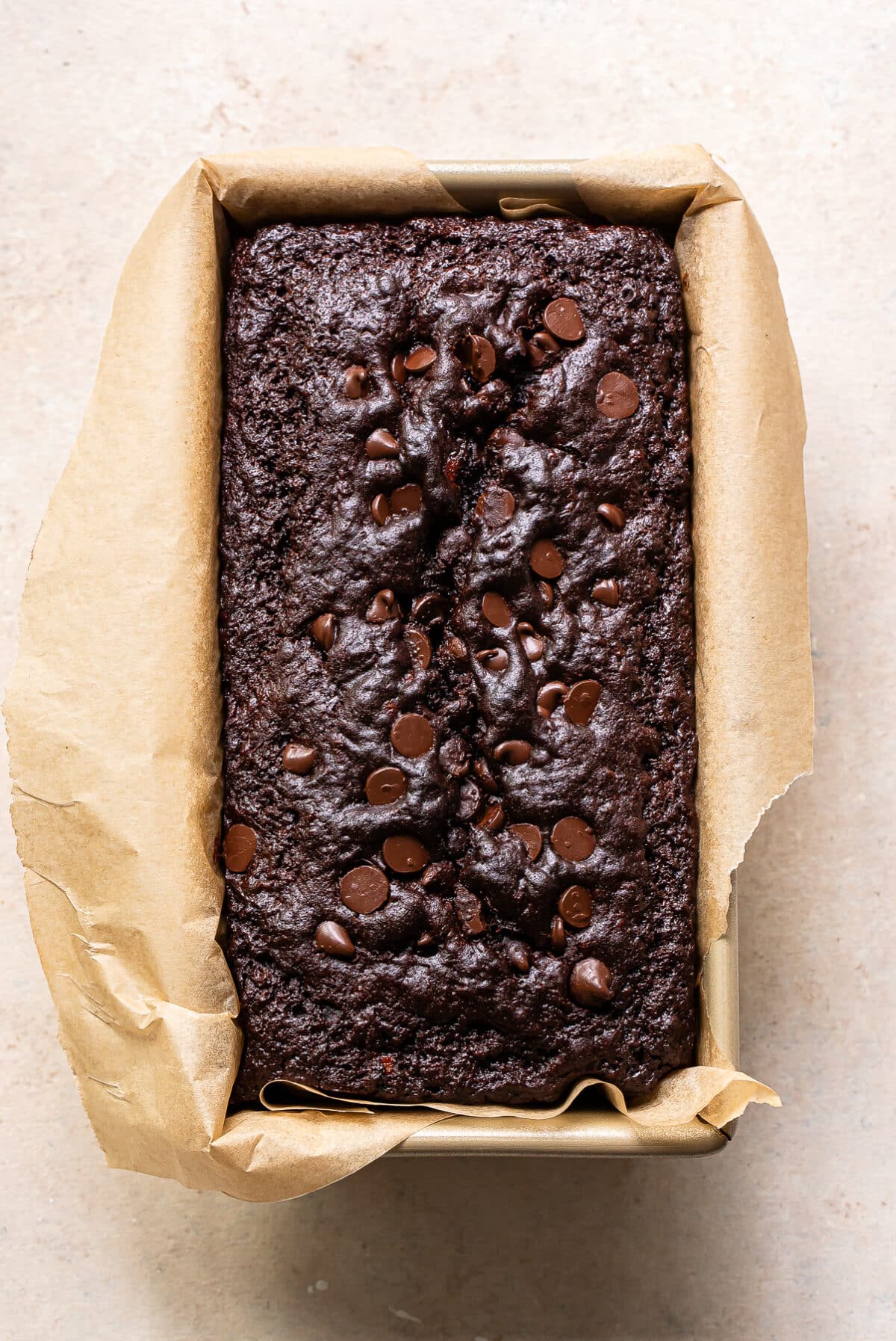 Double chocolate banana bread in a loaf pan with parchment paper.