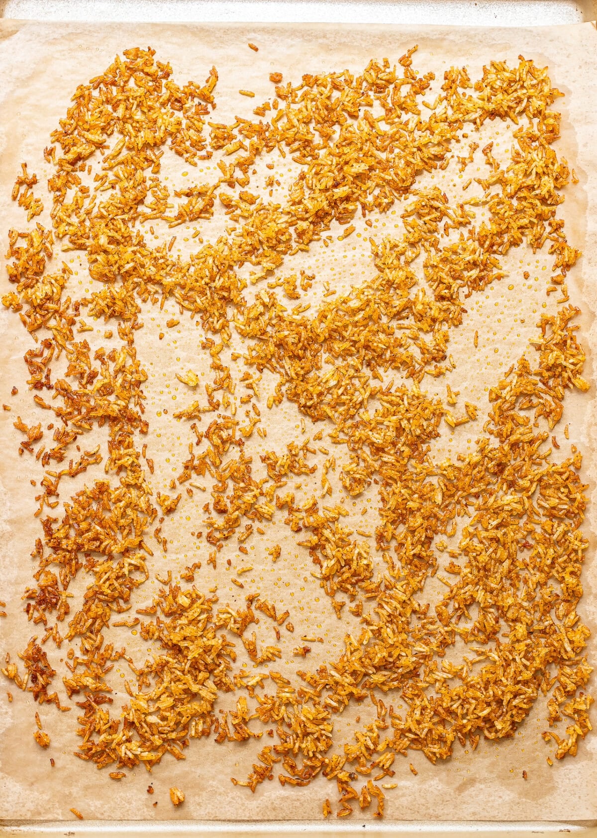 Baked crispy rice on a parchment paper lined baking sheet.