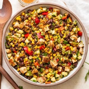 Southwest crispy rice salad with chicken, black beans, and corn in a white serving bowl.